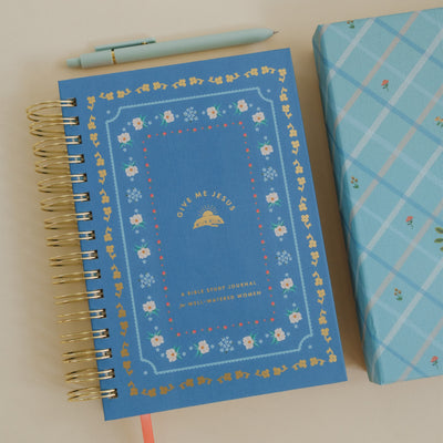 Give Me Jesus Journal with a blue floral cover displayed on a light surface alongside a matching pen and patterned box.