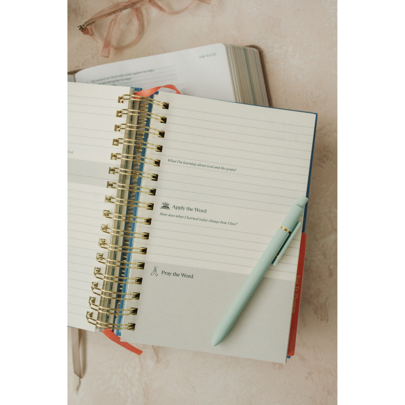 Open Give Me Jesus Journal laying on a table with pages spread and a pen resting on the notebook.